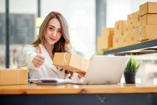 Mujer mostrando satisfacción con CONTPAQi, mientras organiza paquetes con la garantía de calidad que ofrece el software.