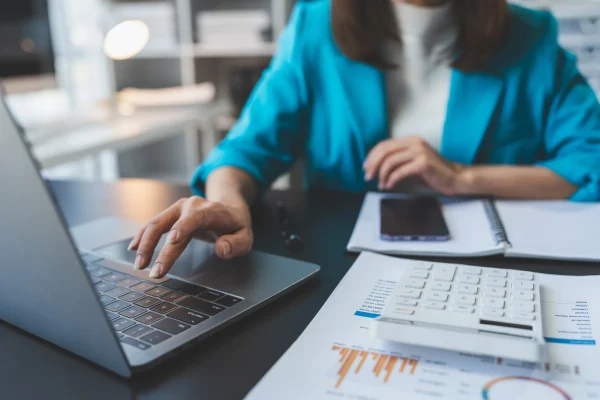 Manos tecleando datos contables con CONTPAQi® Contabilidad. Persona utilizando CONTPAQi® Contabilidad en una laptop para gestionar registros financieros.