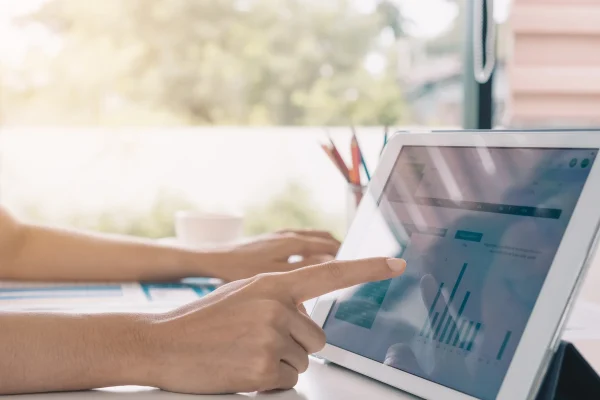 Revisión de indicadores en pantalla para tomar decisiones clave dentro de su gestión de producción empresarial. Ejecutiva analiza gráficas en una laptop para mejorar procesos dentro de la gestión de producción con ayuda de herramientas digitales.