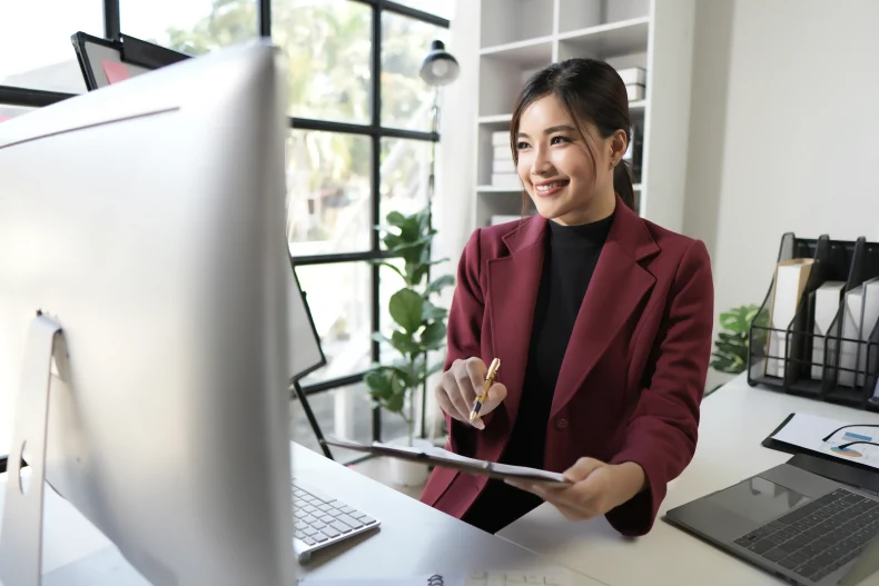 Mujer sonríe al visualizar reportes positivos en su sistema contable, demostrando una gestión financiera clara y eficiente.