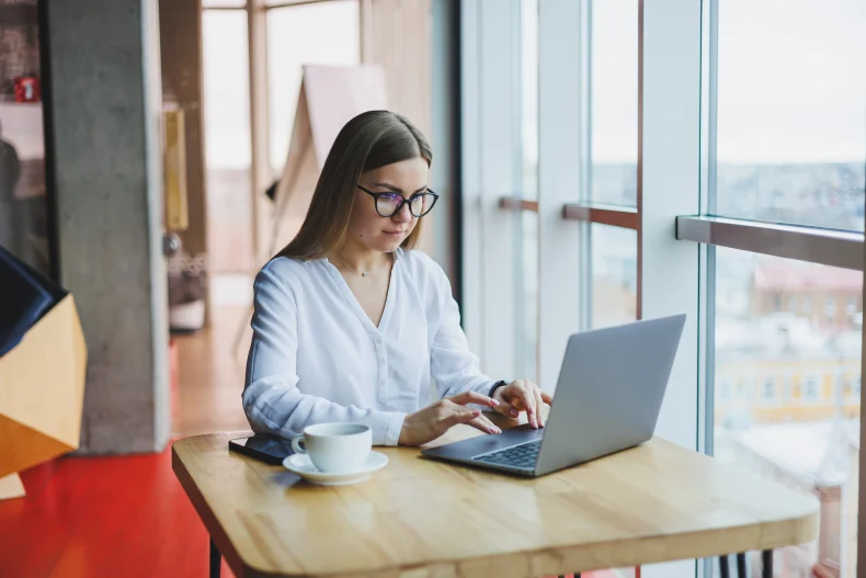 Mujer realiza múltiples tareas desde su computadora con un sistema de facturación electrónica que agiliza sus procesos contables.