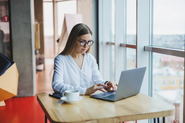 Mujer realiza múltiples tareas desde su computadora con un sistema de facturación electrónica que agiliza sus procesos contables.