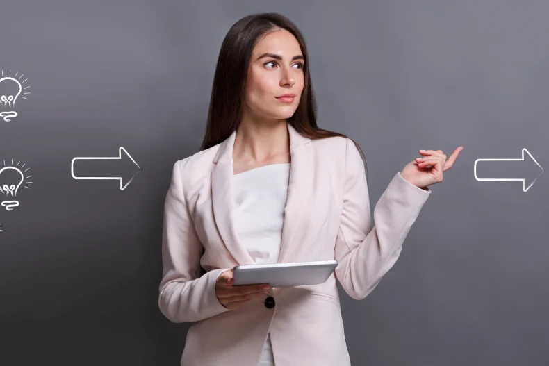 Una profesional de oficina sostiene su tablet mientras apunta hacia un símbolo de dinero, representando ideas y crecimiento en el Día del contador.