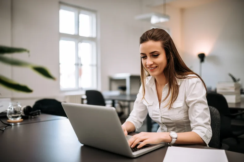 Colaboradora aprende cómo calcular el ISR a través de su computadora gracias a herramientas digitales modernas.