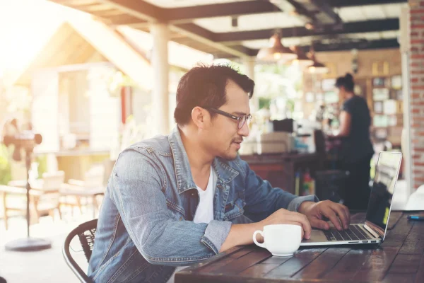 Emprendedor investiga cómo calcular el ISR mientras gestiona su contabilidad desde una cafetería con acceso digital.