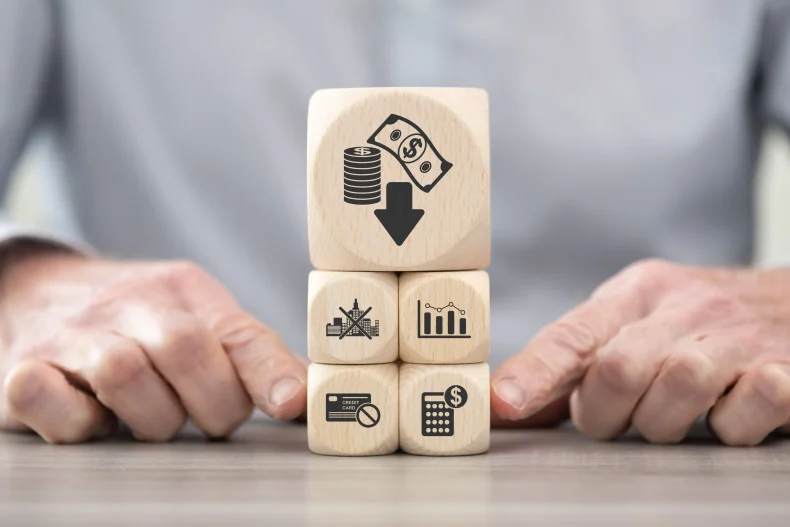 Bloques de madera con íconos de finanzas y gestión representan conceptos clave que forman parte de la contabilidad electrónica.