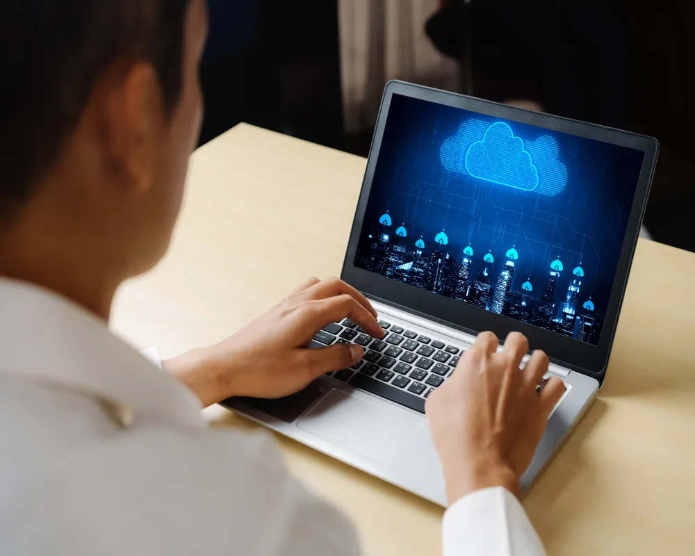 CONTPAQi® nube en funcionamiento sobre una laptop, con una pantalla que proyecta gráficos y redes digitales en tonos azules, simbolizando conexión y almacenamiento seguro.
