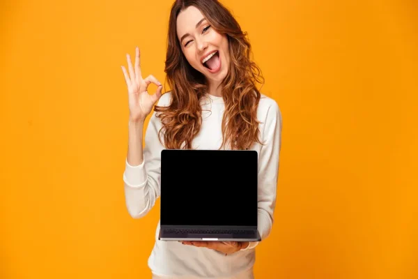 Joven mostrando su laptop con entusiasmo como parte de un proyecto de CONTPAQi® Monterrey.