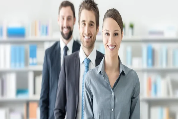 Grupo de compañeros de trabajo mostrando un ambiente positivo mientras comparten experiencias sobre CONTPAQi® Tijuana. Tres colaboradores posando y sonriendo en un entorno laboral vinculado al uso de CONTPAQi® Tijuana.