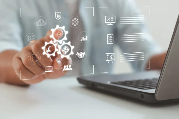 La combinación de laptop e íconos digitales refleja la automatización y organización que caracterizan a CONTPAQi® XML en línea. Una persona interactúa con íconos tecnológicos proyectados sobre la pantalla, representando procesos de gestión como los que ofrece CONTPAQi® XML en línea.
