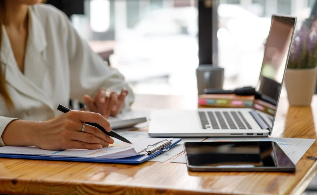 Empleado administrativo registrando datos de nómina mientras aprende cómo automatizar el cálculo de impuestos y deducciones con herramientas digitales.
