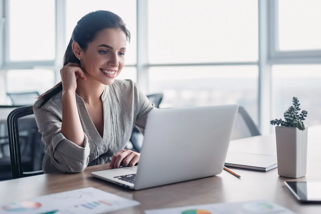 Mujer trabajando con un software contable desde su computadora portátil, gestionando de forma eficiente la contabilidad de su negocio.