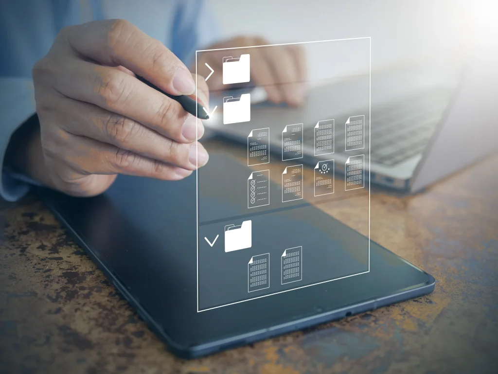 Íconos de documentos sobre una superficie táctil, señalando soluciones de respaldo de datos como soporte del almacenamiento. Carpetas virtuales se organizan en una tableta, representando soluciones de respaldo de datos.
