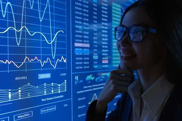 Vista enfocada de una mujer en donde se le pueden reflejar los gráficos financieros digitales.