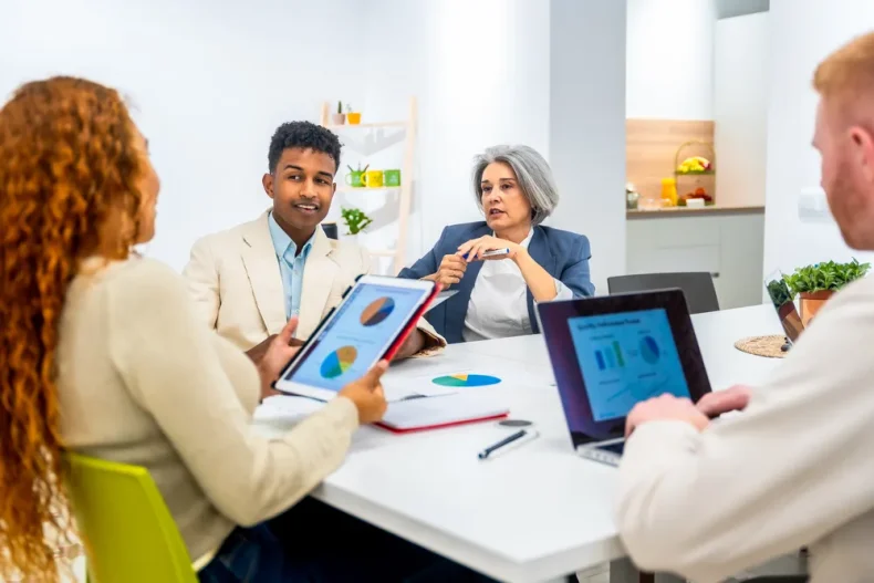 Equipo revisando gráficos financieros y discutiendo sobre ellos.