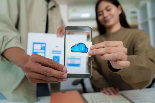 Dos personas mostrando las diferencias entre un sistema contable local y uno en la nube, mientras se sostiene los ejemplo.