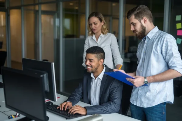 Un equipo de trabajo feliz, mientras observan el éxito del software de control administrativo.