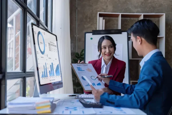 Análisis de un crecimiento a través de unas gráficas Vista general de dos personas checando los gráficos de crecimiento y resultados positivos en un entorno empresarial.