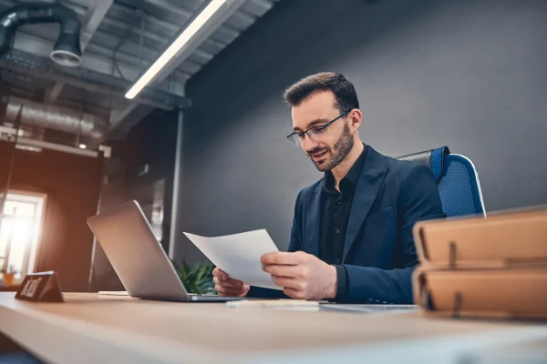 Persona organizando archivos digitales con Contpaqi escritorio virtual mientras analiza información impresa. Profesional revisando documentos junto a su equipo con apoyo de Contpaqi escritorio virtual en procesos laborales.