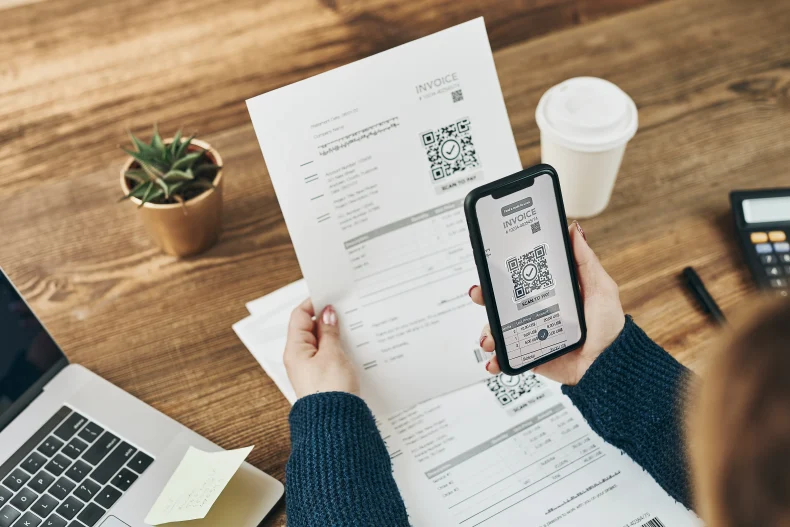 Persona escaneando el código QR de una factura para conocer qué tipos de CFDI existen y cómo emitirlos en CONTPAQi®.