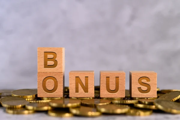 Ejemplo de simulación de un elemento de los tipos de nóminas en México. Vista general de unos cubos con la palabra “Bonus” y varias monedas en la mesa haciendo relación al elemento que se puede incluir en los tipos de nóminas en México.